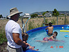 Tyler watching Ken putting Jordan's feet in the pool