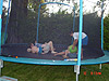 The kids playing the the ball on the trampoline
