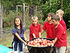 The kids carrying the apples